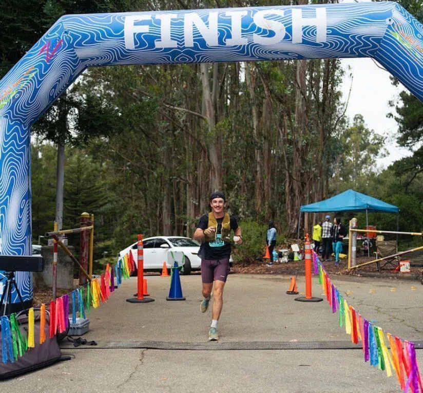 Dennis crossing the finish line of a trail run
