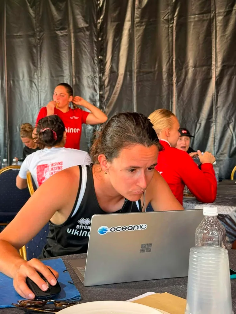 Emilie working on video analysis at a tournament, with an Ocean.io sticker on the laptop