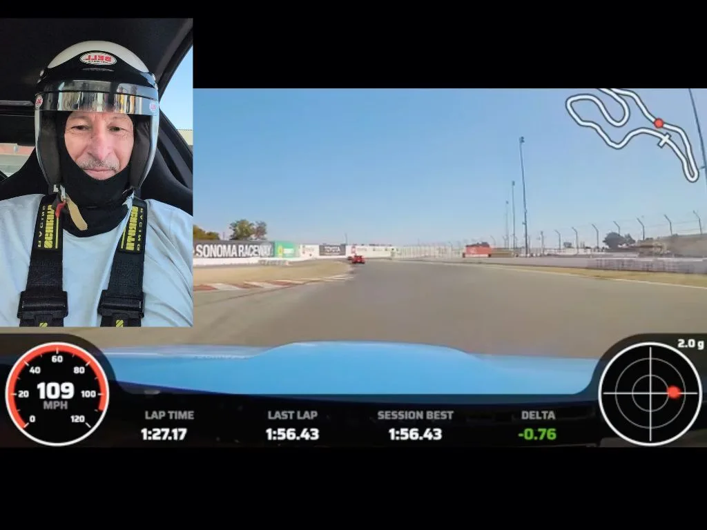 Michael in a helmet during a lap at Sonoma Raceway, with the track ahead and live lap data on screen
